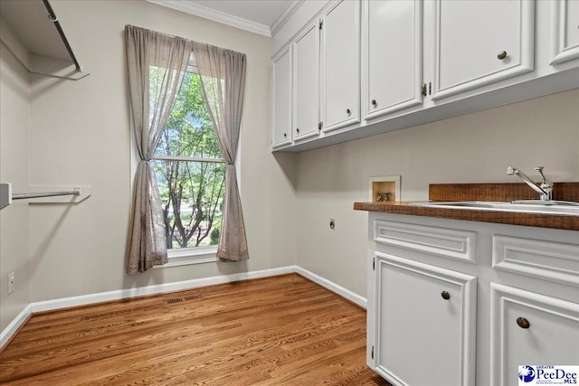 3427 Sussex Ct, Florence, SC 29501 - washroom with crown molding, hookup for a washing machine, wood finished floors, cabinet space, and electric dryer hookup