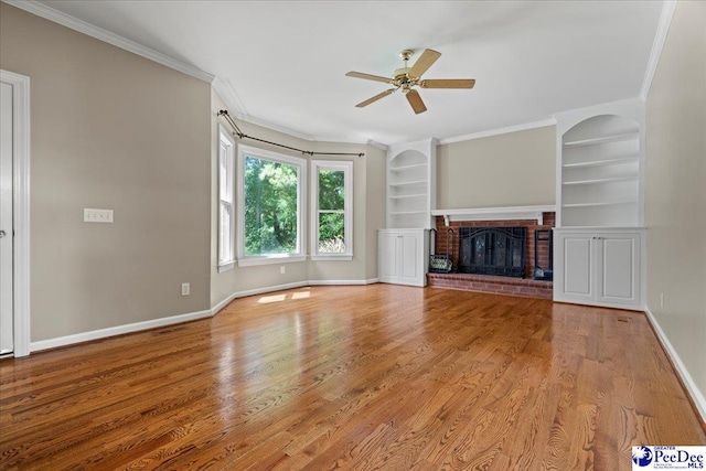 3427 Sussex Ct, Florence, SC 29501 - unfurnished living room with built in shelves, ceiling fan, wood finished floors, a brick fireplace, and ornamental molding