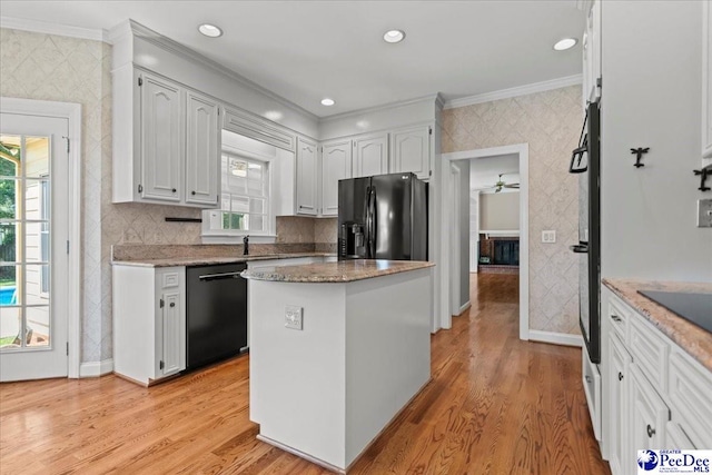 3427 Sussex Ct, Florence, SC 29501 - kitchen with black appliances, crown molding, plenty of natural light, white cabinets, and wallpapered walls