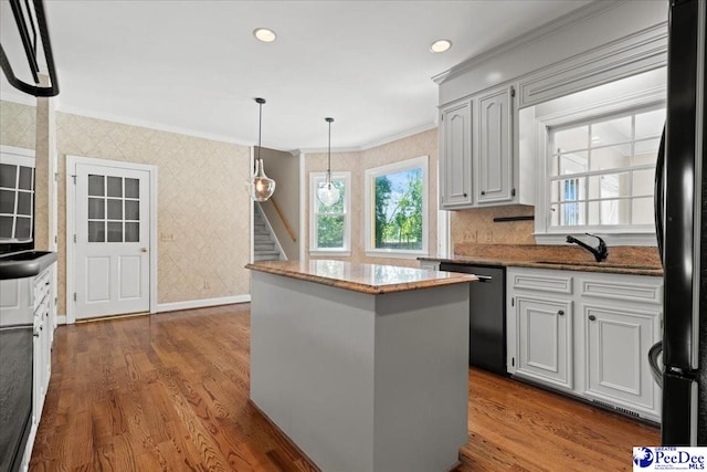 3427 Sussex Ct, Florence, SC 29501 - kitchen with dishwasher, wallpapered walls, ornamental molding, a center island, and dark wood finished floors