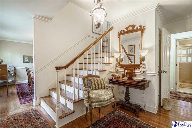 stairway featuring hardwood / wood-style flooring and ornamental molding