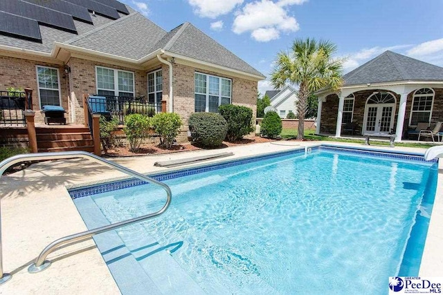 view of pool with an outbuilding and french doors