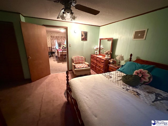 bedroom featuring crown molding, carpet, ceiling fan, and a textured ceiling