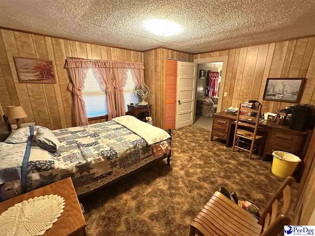 carpeted bedroom with a closet, a textured ceiling, and wood walls