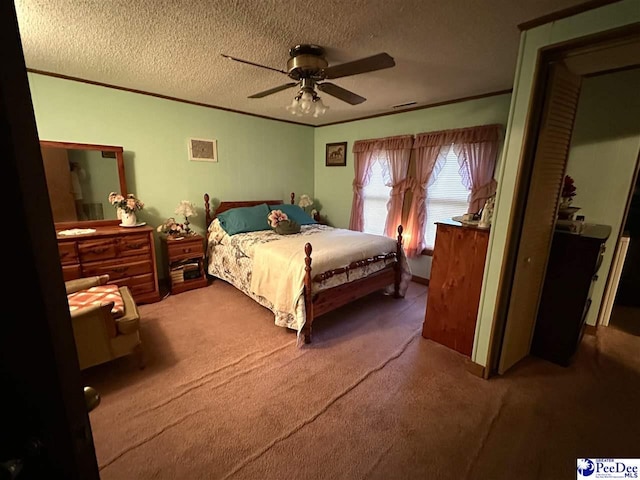 bedroom with ceiling fan, crown molding, carpet floors, and a textured ceiling