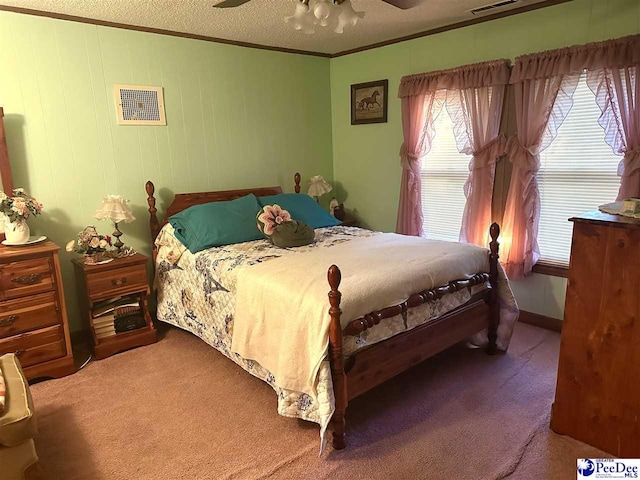 carpeted bedroom with ceiling fan, crown molding, and a textured ceiling