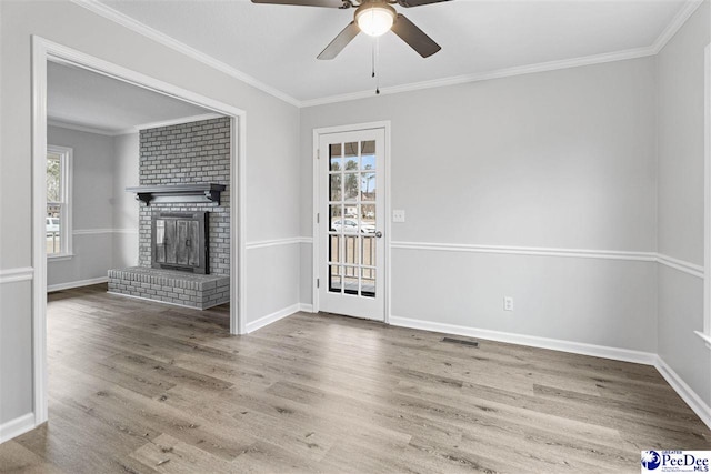 unfurnished living room with hardwood / wood-style flooring, ceiling fan, ornamental molding, and a fireplace