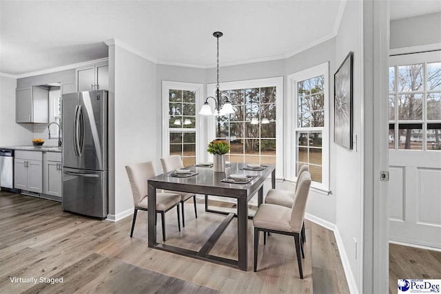 dining space featuring a notable chandelier, a wealth of natural light, and light hardwood / wood-style flooring