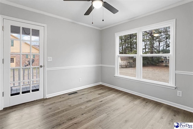 empty room with hardwood / wood-style flooring, ceiling fan, and crown molding