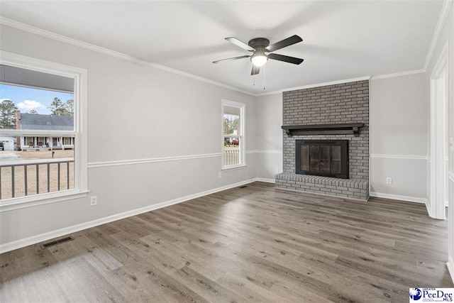 unfurnished living room featuring crown molding, a brick fireplace, and hardwood / wood-style flooring