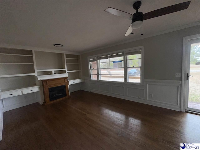 unfurnished living room featuring ornamental molding, dark wood-type flooring, ceiling fan, and built in shelves