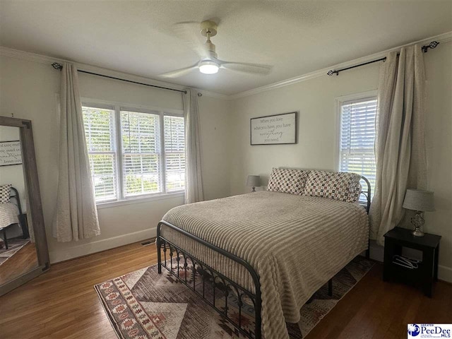 412 W Greene St, Cheraw, SC 29520 - bedroom featuring multiple windows, ornamental molding, wood finished floors, and a ceiling fan
