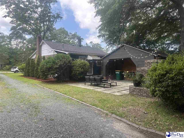 412 W Greene St, Cheraw, SC 29520 - back of house with a patio, an outdoor living space, and a chimney