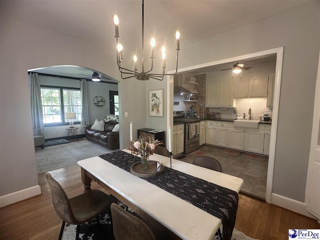 412 W Greene St, Cheraw, SC 29520 - dining area with ceiling fan, arched walkways, a chandelier, and dark wood-type flooring