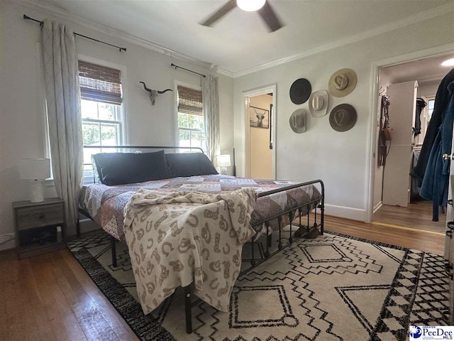 412 W Greene St, Cheraw, SC 29520 - bedroom with ornamental molding, wood-type flooring, a spacious closet, and ceiling fan