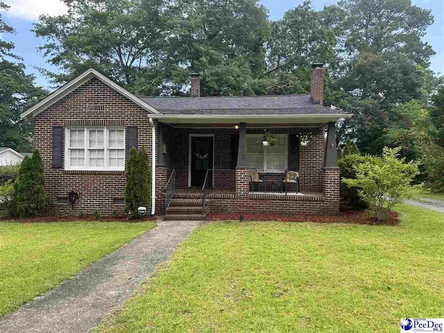 412 W Greene St, Cheraw, SC 29520 - bungalow-style house with brick siding, a chimney, and a front yard