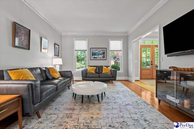 living area with crown molding, baseboards, and wood finished floors