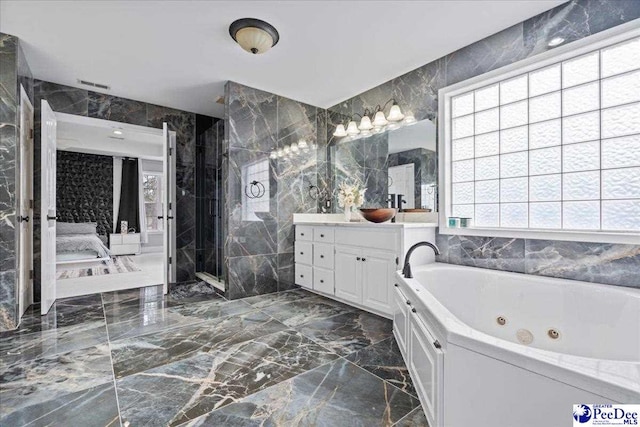 ensuite bathroom with a tub with jets, visible vents, a shower stall, tile walls, and marble finish floor