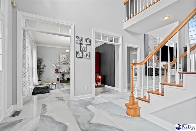 foyer featuring stairway, visible vents, baseboards, crown molding, and marble finish floor