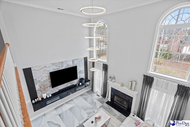 living area featuring a fireplace, crown molding, and an inviting chandelier