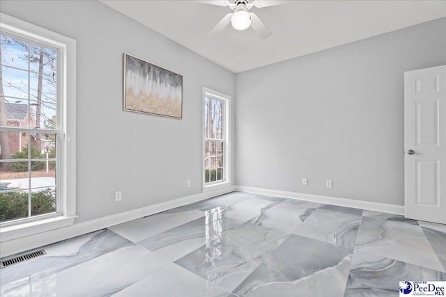 spare room featuring visible vents, baseboards, and a ceiling fan