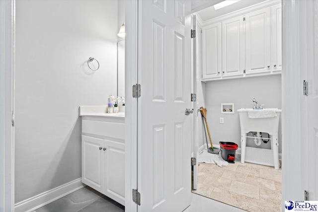 washroom with baseboards, hookup for a washing machine, and laundry area