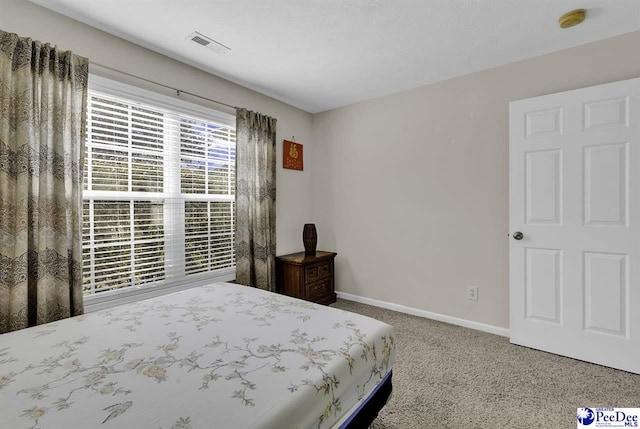 carpeted bedroom with visible vents and baseboards