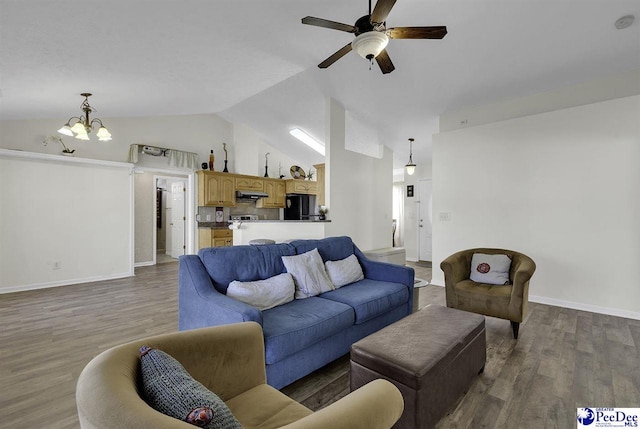 living area featuring ceiling fan with notable chandelier, vaulted ceiling, baseboards, and wood finished floors