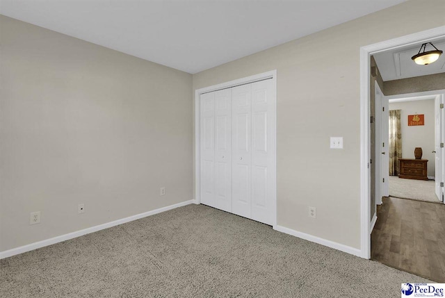 unfurnished bedroom with carpet floors, a closet, and baseboards