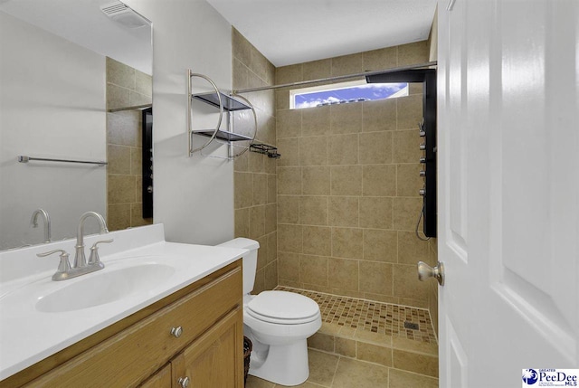 bathroom featuring toilet, tile patterned flooring, a shower stall, and vanity