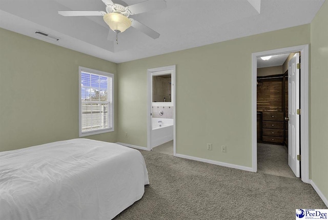 bedroom with a spacious closet, carpet floors, visible vents, and baseboards