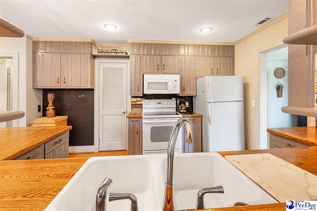 kitchen featuring white appliances, crown molding, wooden counters, recessed lighting, and a sink