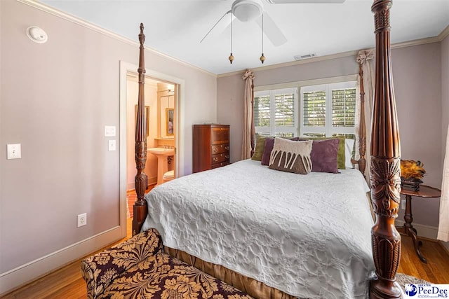 bedroom with wood finished floors, baseboards, crown molding, connected bathroom, and a ceiling fan