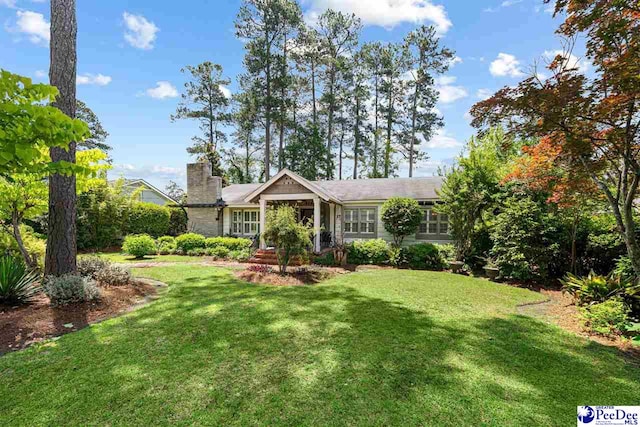 single story home featuring a chimney and a front yard