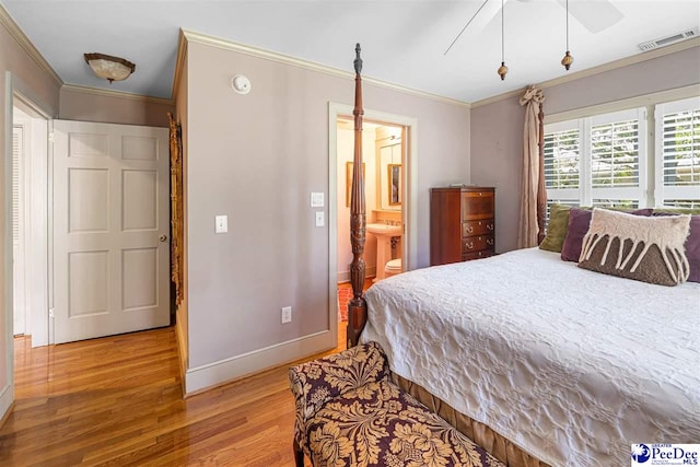 bedroom with baseboards, crown molding, light wood-type flooring, ensuite bathroom, and a ceiling fan