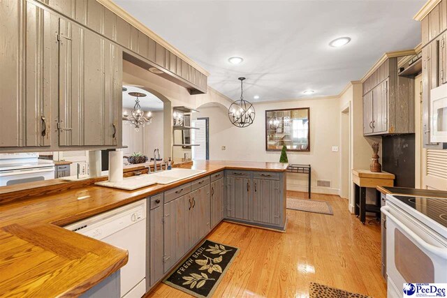 kitchen with a chandelier, white appliances, gray cabinets, a peninsula, and recessed lighting