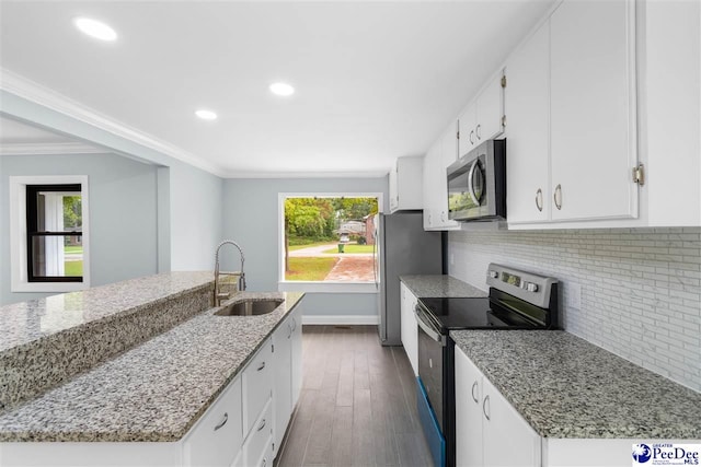 kitchen with appliances with stainless steel finishes, light stone countertops, sink, and white cabinets