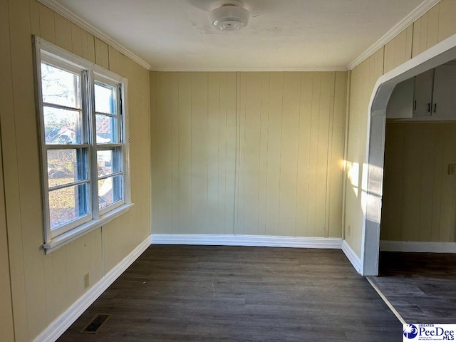 unfurnished room featuring dark wood-type flooring and ornamental molding