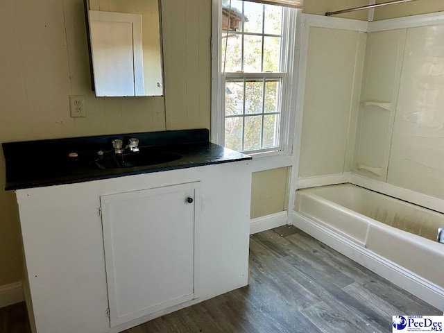 bathroom featuring hardwood / wood-style flooring, vanity, and shower / bathing tub combination