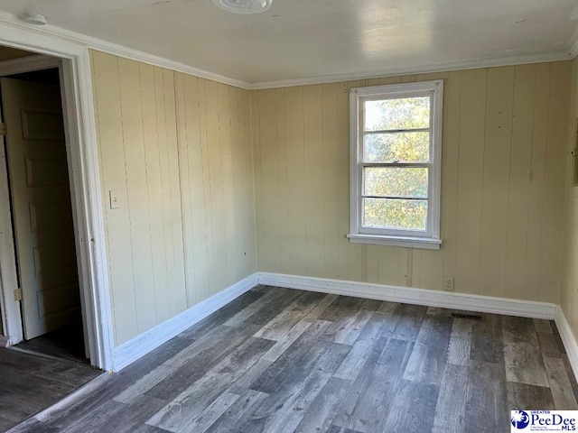 spare room featuring crown molding and dark hardwood / wood-style floors