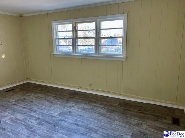 spare room with dark wood-type flooring and ornamental molding