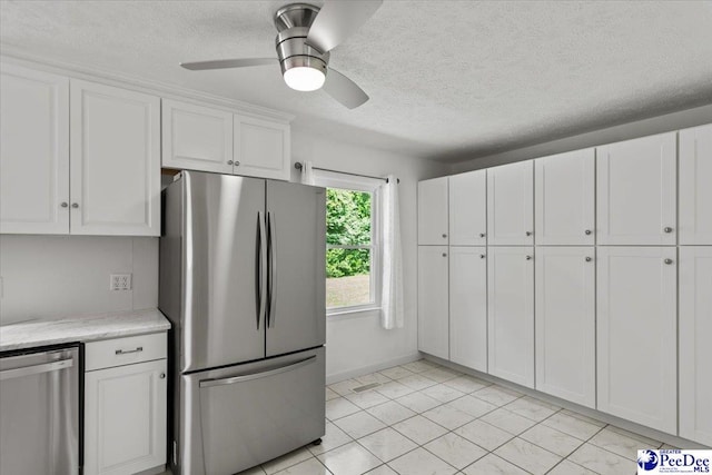 317 Thomas St, Bennettsville, SC 29512 - kitchen with appliances with stainless steel finishes, white cabinetry, a textured ceiling, a ceiling fan, and light tile patterned flooring