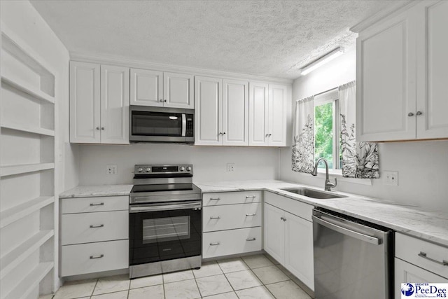 317 Thomas St, Bennettsville, SC 29512 - kitchen featuring stainless steel appliances, open shelves, white cabinetry, light stone counters, and a textured ceiling