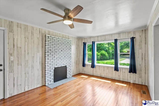317 Thomas St, Bennettsville, SC 29512 - unfurnished room featuring hardwood / wood-style flooring, a ceiling fan, a brick fireplace, ornamental molding, and wooden walls
