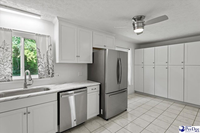 317 Thomas St, Bennettsville, SC 29512 - kitchen with appliances with stainless steel finishes, a textured ceiling, white cabinets, ceiling fan, and light stone counters