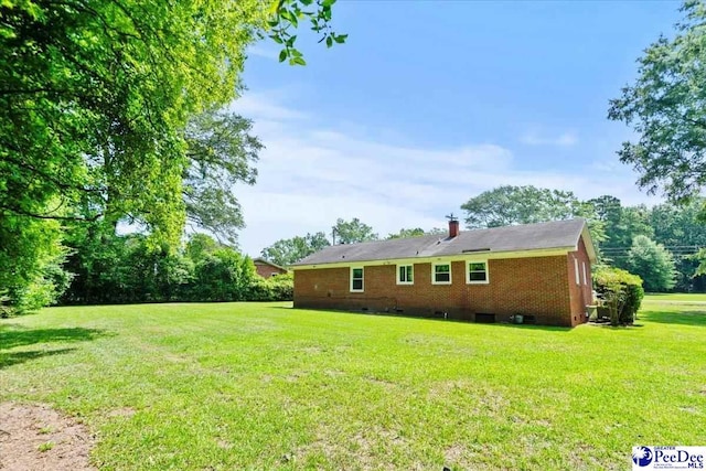317 Thomas St, Bennettsville, SC 29512 - view of side of home with a lawn, brick siding, crawl space, and a chimney