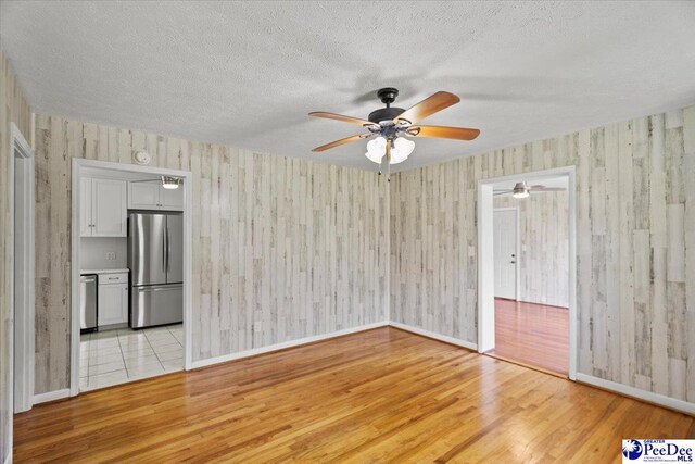 317 Thomas St, Bennettsville, SC 29512 - unfurnished living room with light wood-style floors, a ceiling fan, and a textured ceiling