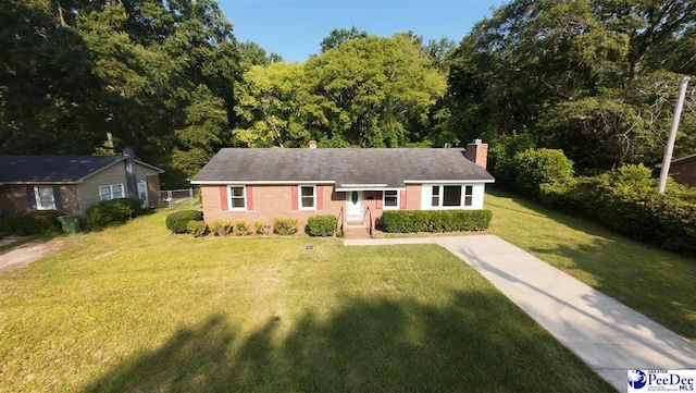 317 Thomas St, Bennettsville, SC 29512 - ranch-style house with a chimney, a front lawn, and brick siding
