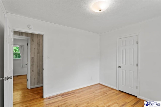 317 Thomas St, Bennettsville, SC 29512 - empty room featuring light wood-type flooring, a textured ceiling, crown molding, and a smoke detector