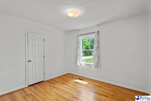 317 Thomas St, Bennettsville, SC 29512 - unfurnished room featuring a textured ceiling, light wood-style flooring, and ornamental molding